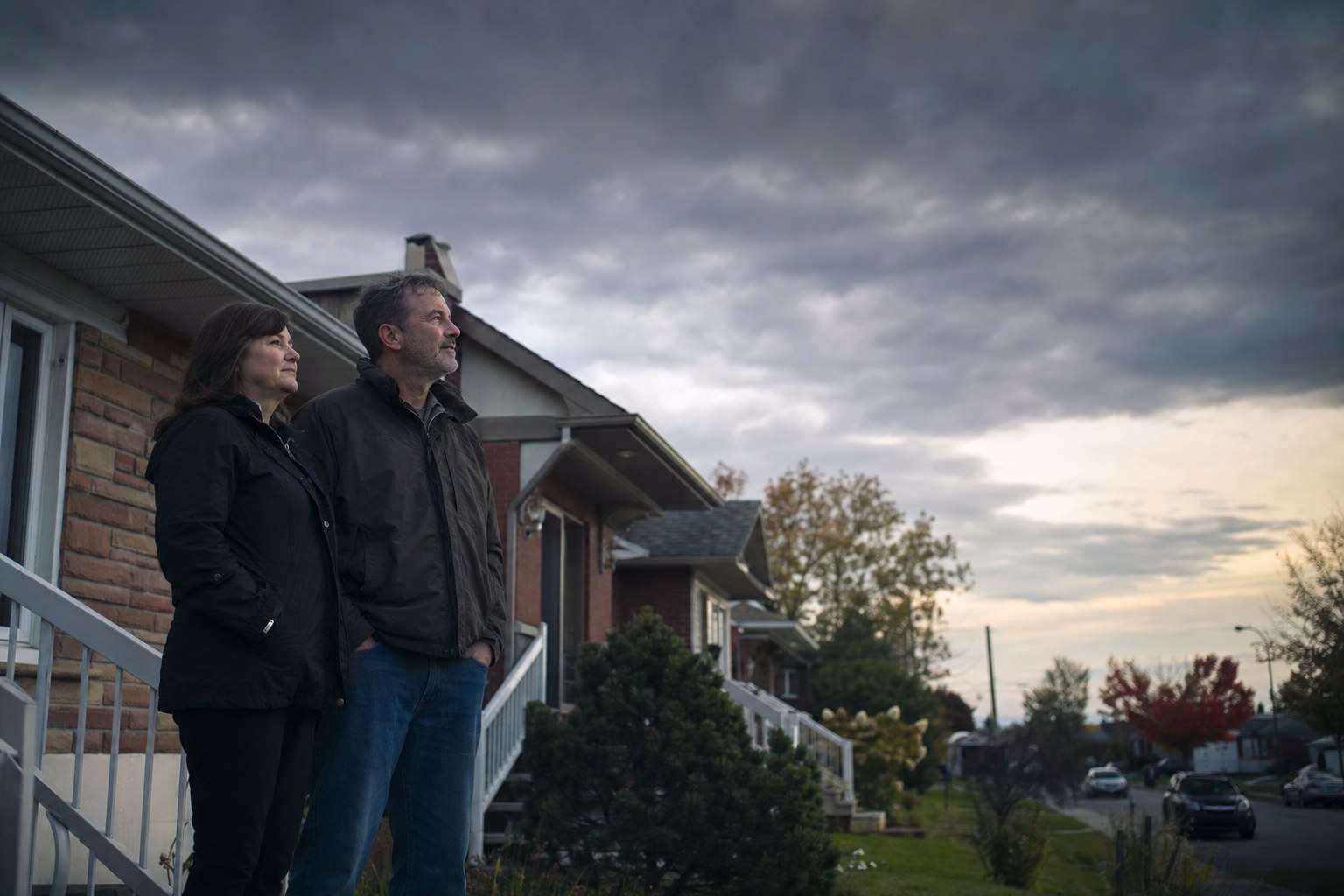 Un couple dans la cinquantaine sur le perron de son bungalow.