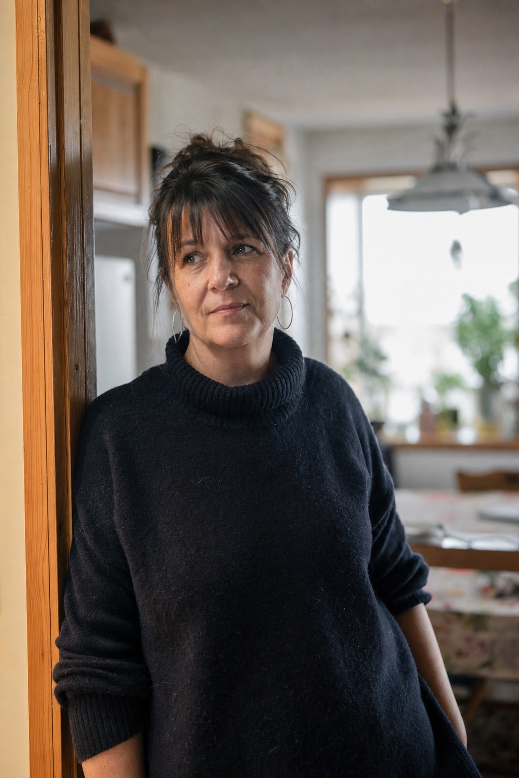 Une femme dans la cinquantaine, chez elle, calme.